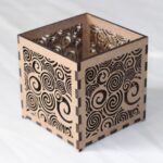 Small laser-cut MDF T-light holder with swirling pattern