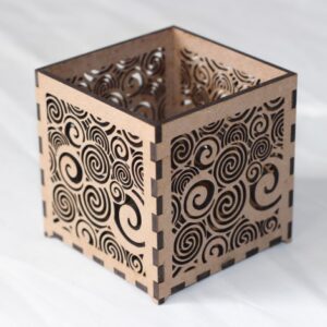 Small laser-cut MDF T-light holder with swirling pattern